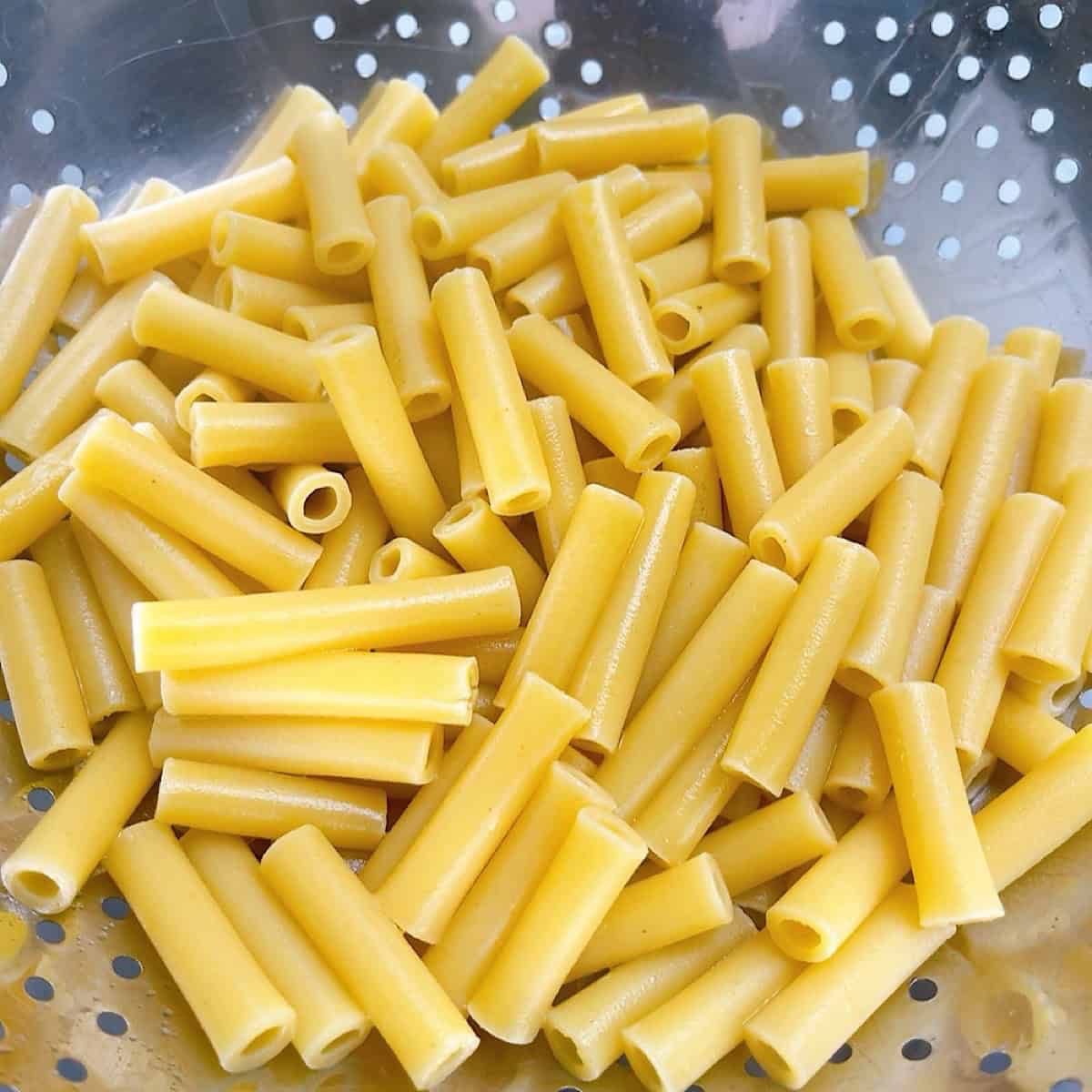 Ziti pasta draining in a colander.