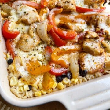 Cheesy chicken fajita bake with oregano sprinkled over top in a casserole dish.