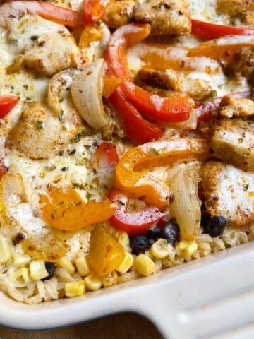 Cheesy chicken fajita bake with oregano sprinkled over top in a casserole dish.