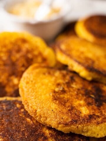 Hoecakes on an elegant platter with a side of honey butter.