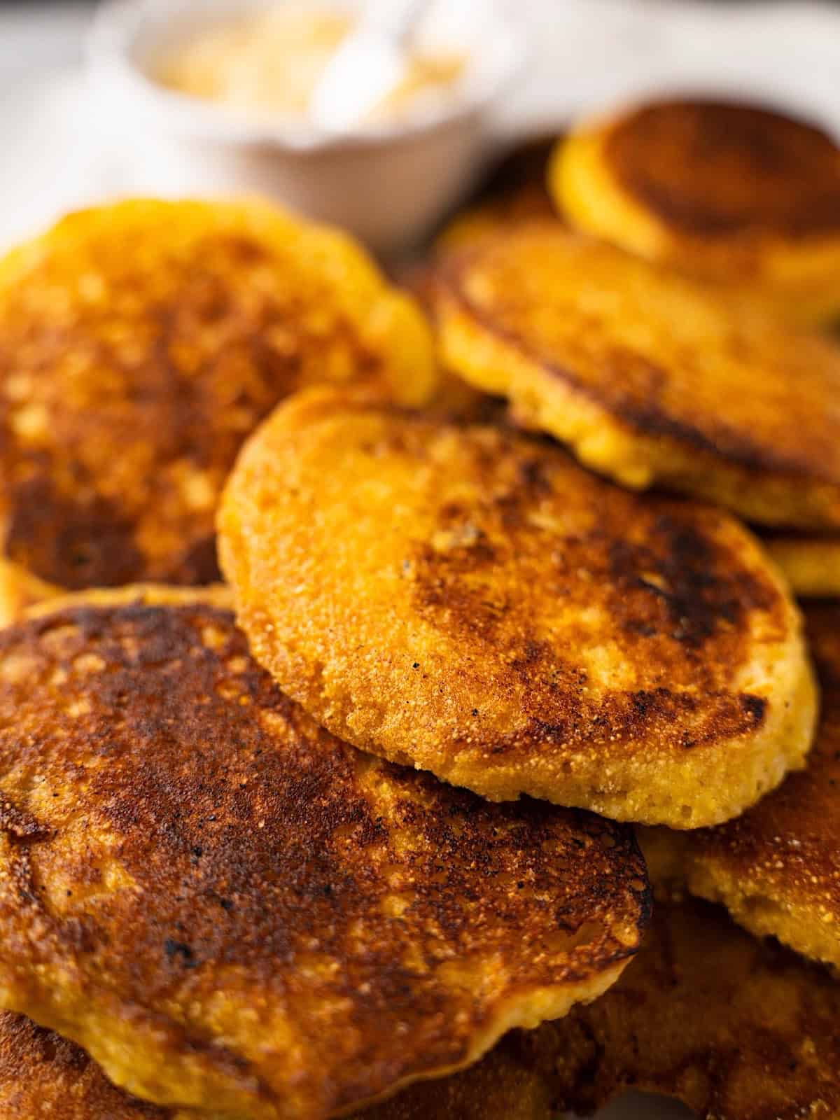 Hoecakes on an elegant platter with a side of honey butter.