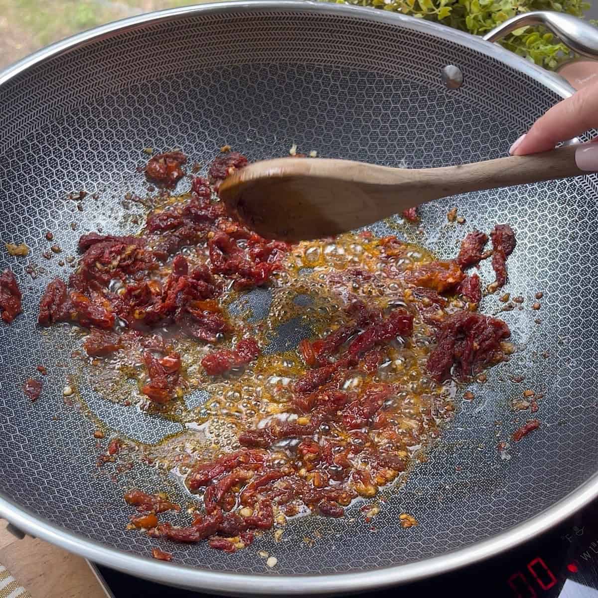 Sauteeing garlic and sundried tomatoes in butter.
