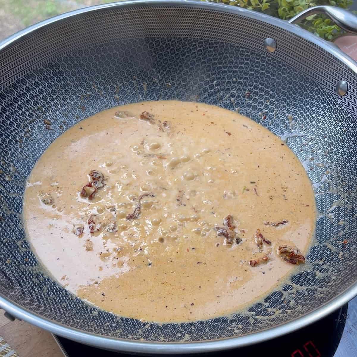 Creamy tomato cream sauce simmering on stove.