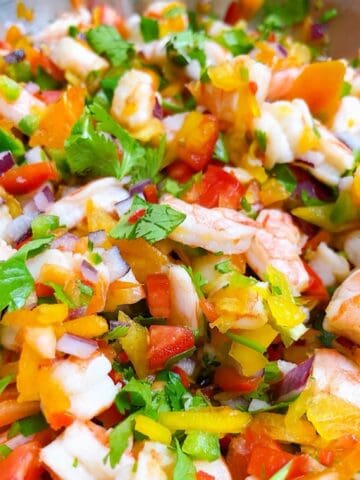 A large bowl of shrimp ceviche with cooked shrimp.