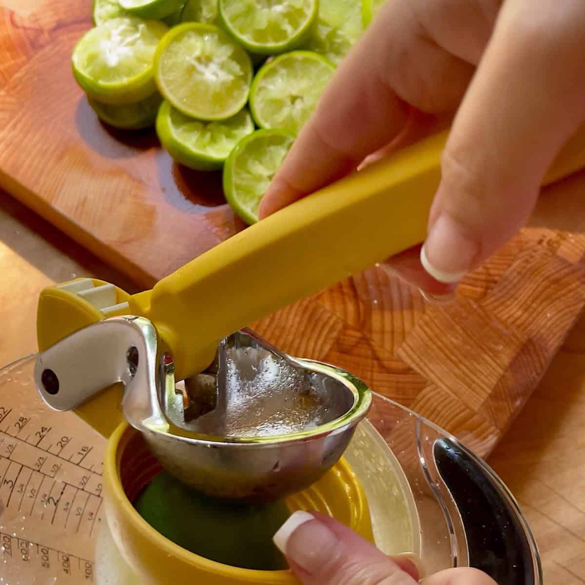 Juicing the limes with a citrus squeezer.
