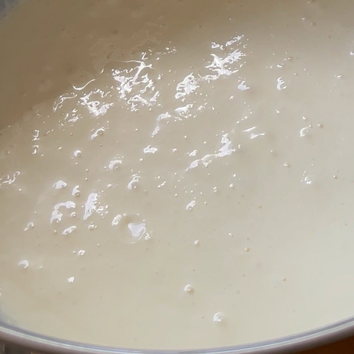 Cream cheese and condensed milk whipped together in bowl.