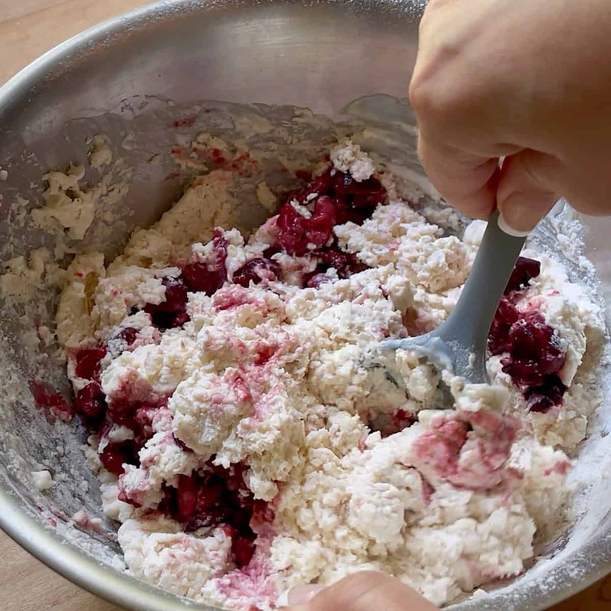 Folding cherries into the wet dough.