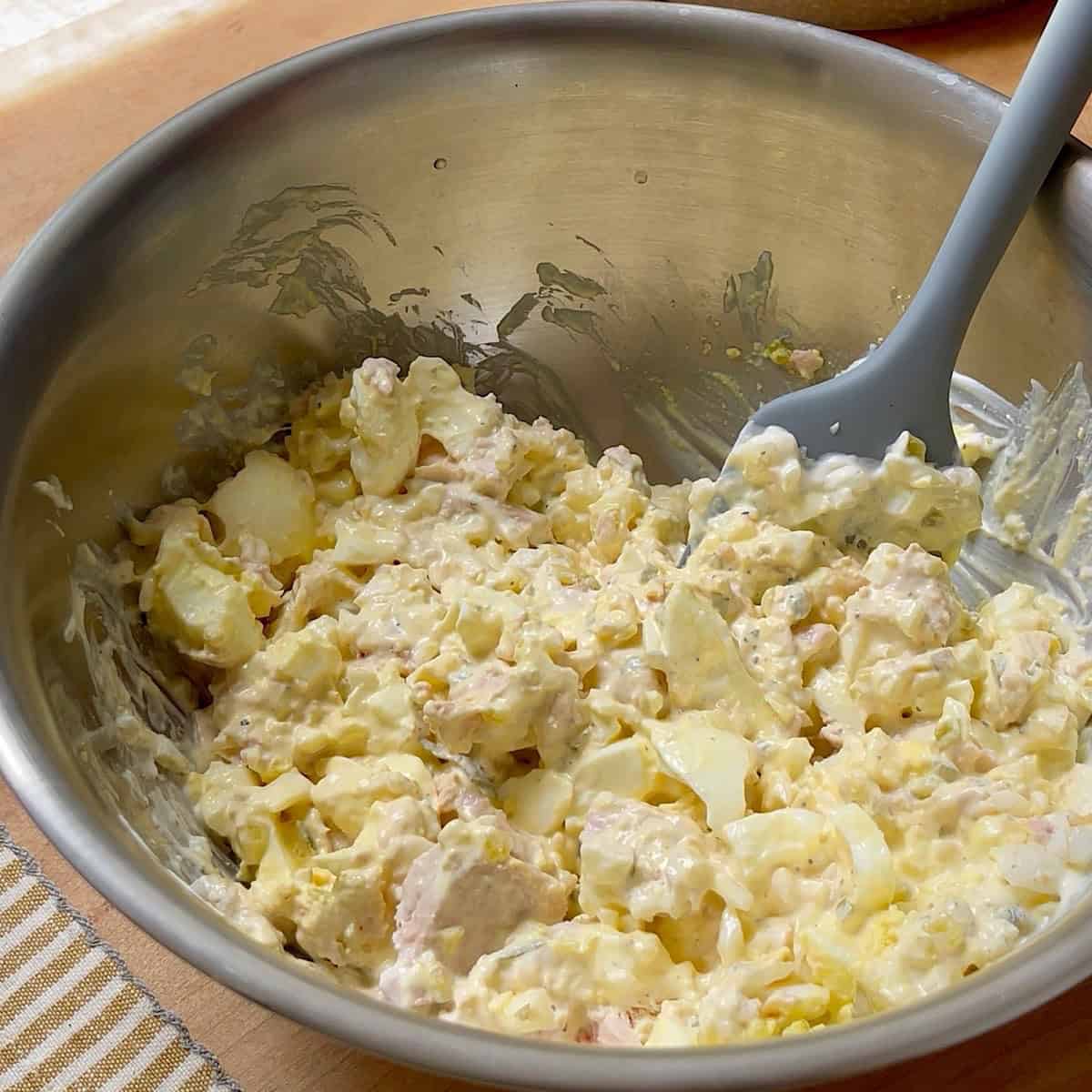 Tuna egg salad ingredients stirred together.