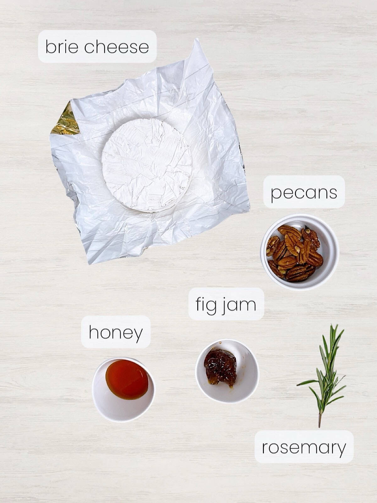 A labeled image of everything needed to make baked brie with fig jam and pecans.