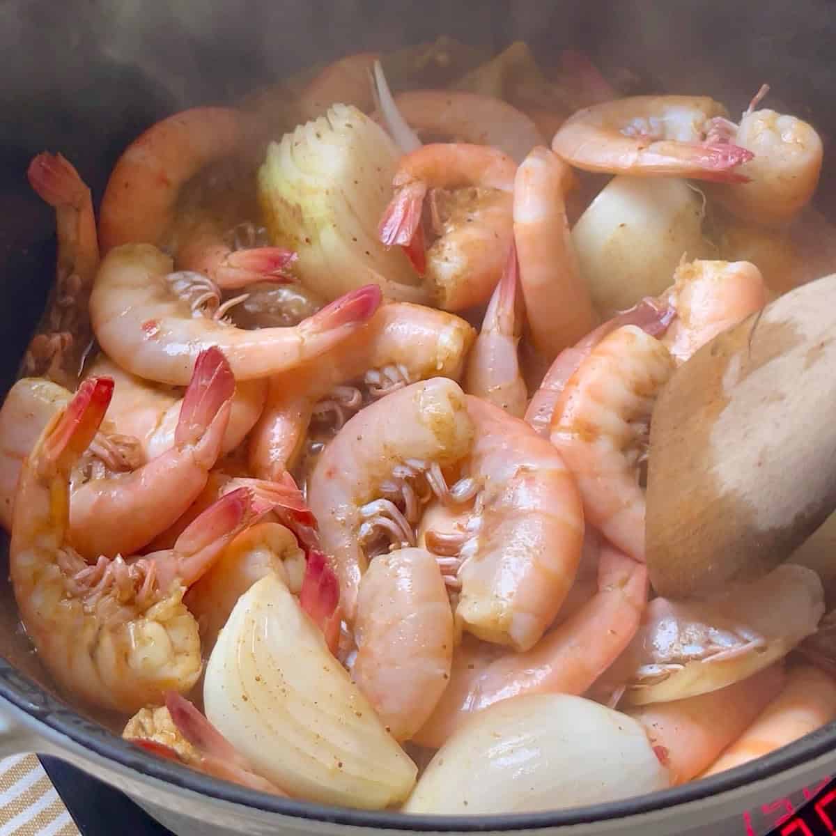 Boiling the shrimp with remaining ingredients.