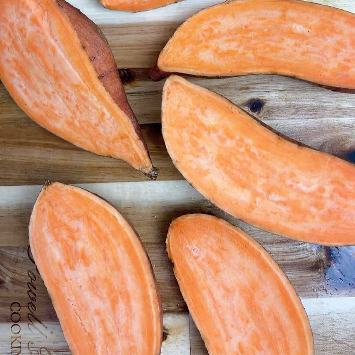 Washed and halved sweet potatoes on a baking sheet.