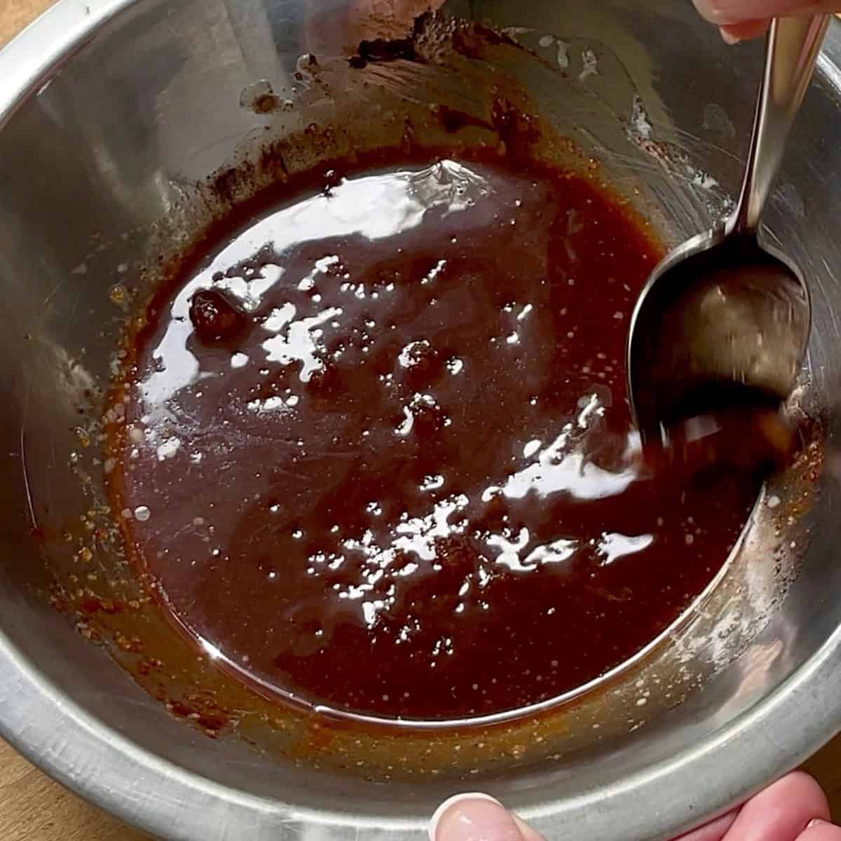 Brown sugar glaze being mixed in a bowl.