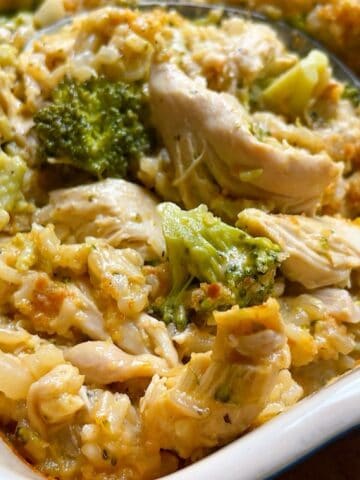 A large serving spoon in the chicken broccoli rice bake without soup to show the inside of the casserole.