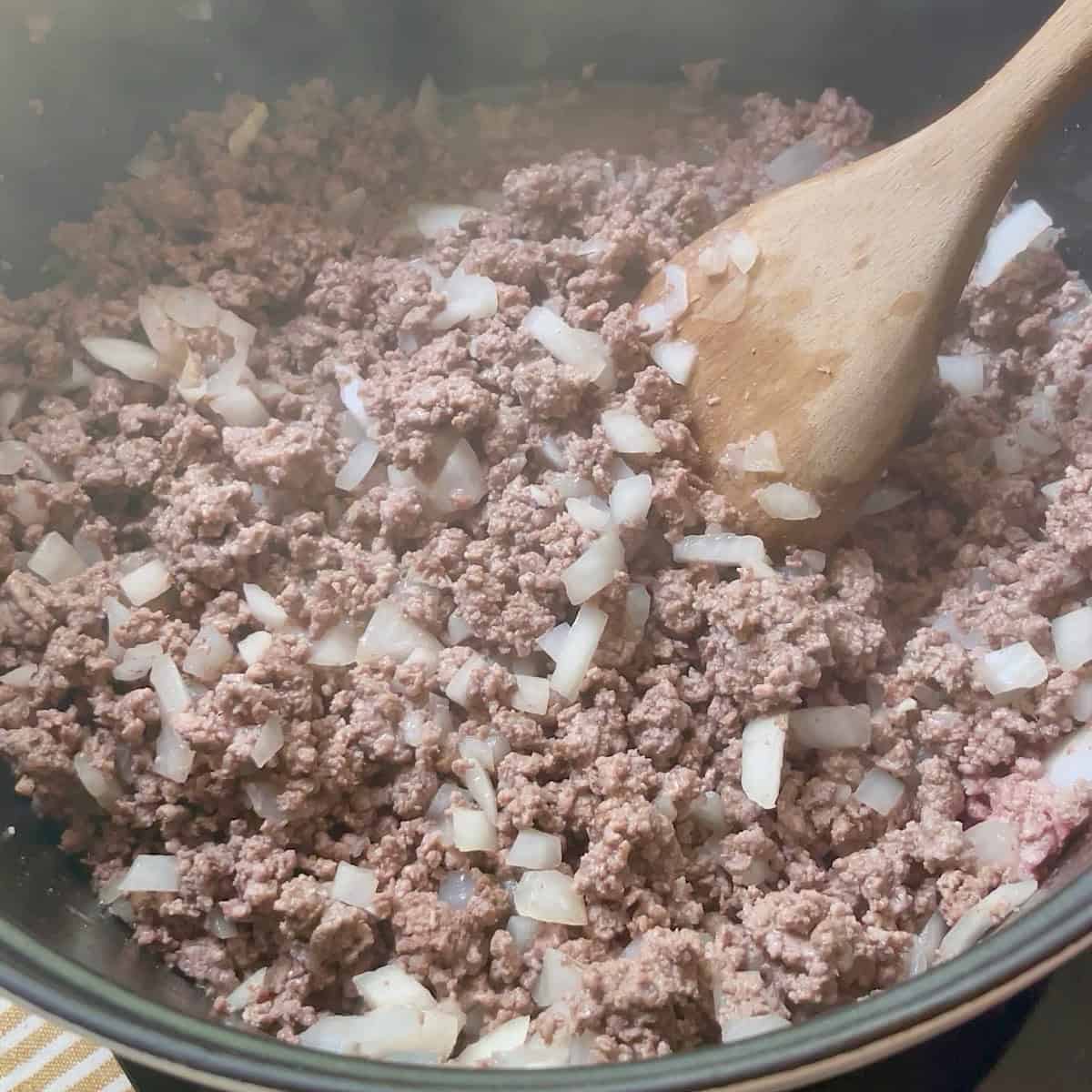 Browning ground beef with onion in a dutch oven.