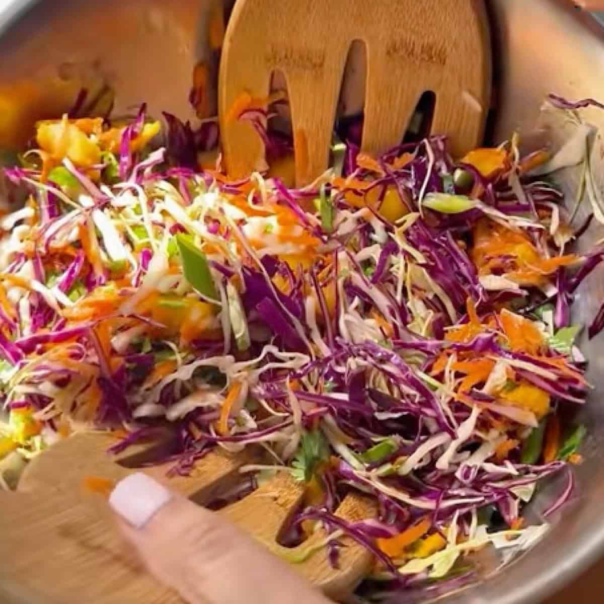 Tossing together the mango slaw with the honey lime dressing.