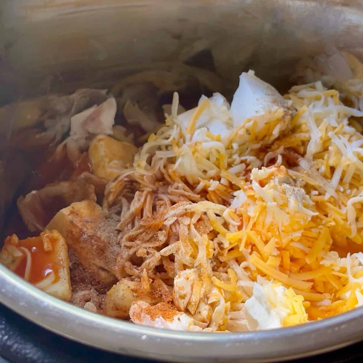 An image of all the buffalo chicken dip ingredients in the Instant Pot.