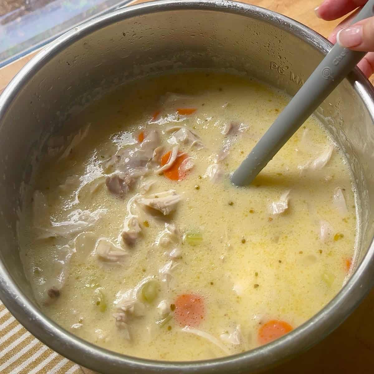 Lemon egg mixture poured back into the avgolemono soup with shredded chicken.
