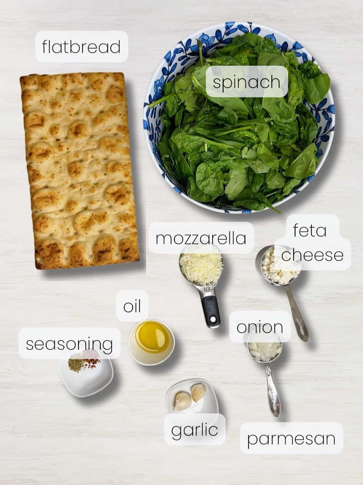 A labeled image of everything needed to make spinach and feta pizza.