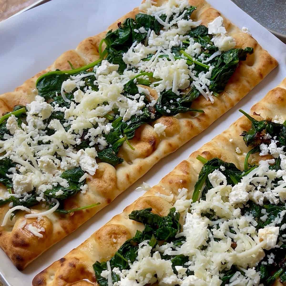 Sauteed spinach mixture and cheeses evenly spread over crusts.