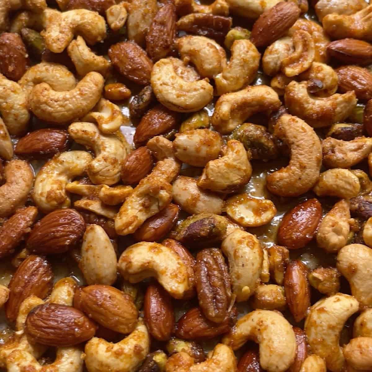Roasted nuts with candy coating cooled on a sheet pan.