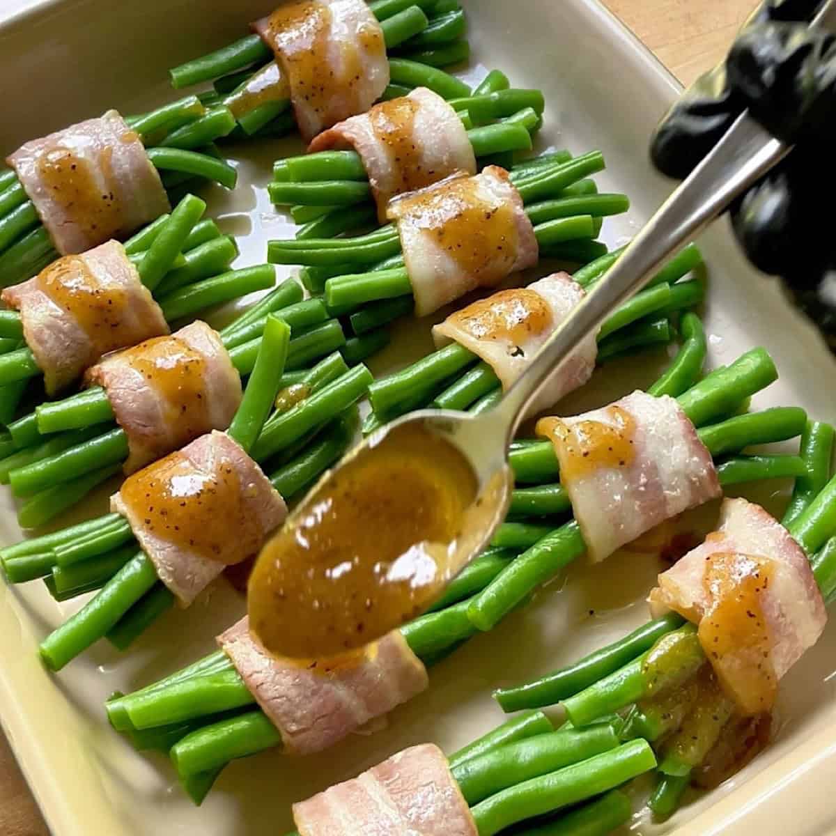 Green bean and bacon bundles assembled with brown sugar glaze over top.