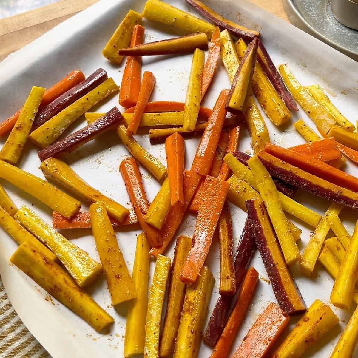 Carrot fries arranged in a single layer on a baking sheet.