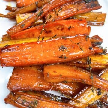 Carrots and parsnips with honey butter glaze on a platter.