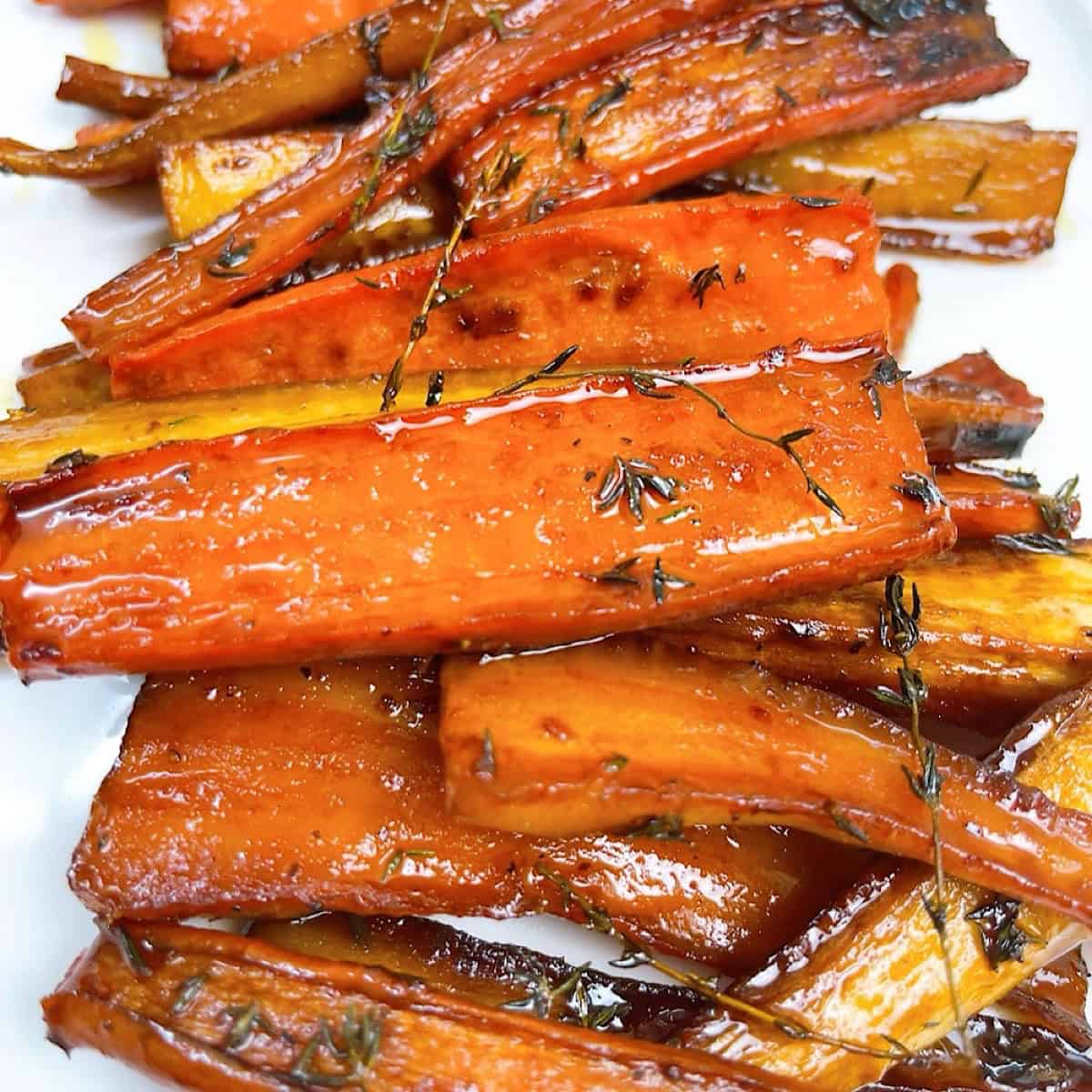 Carrots and parsnips with honey butter glaze on a platter.
