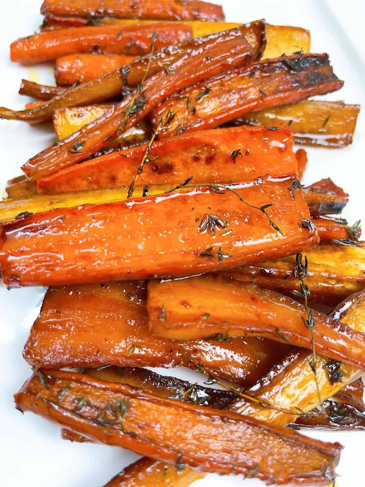 Carrots and parsnips with honey butter glaze on a platter.