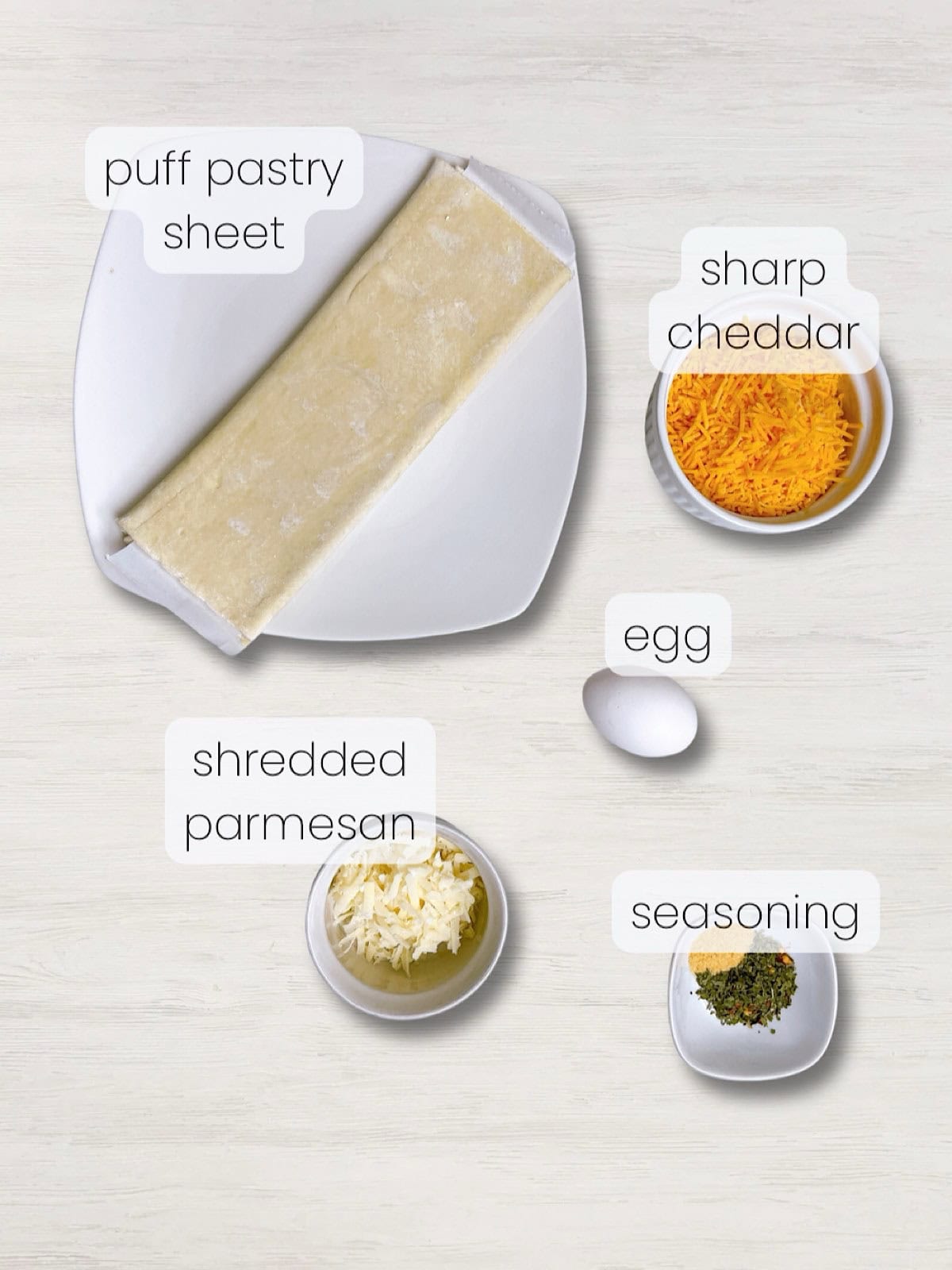 A labeled image of everything needed to make cheesy puff pastry straws or cheese twists.