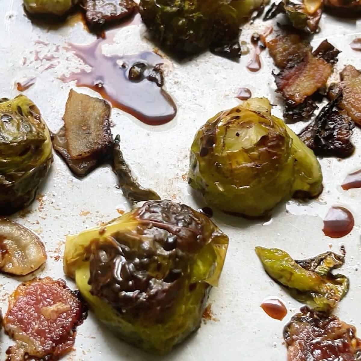 Roasted brussels sprouts and bacon on the sheet pan drizzled with balsamic glaze.