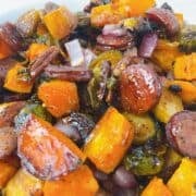 Fall sheet pan sausage, brussels sprouts, and sweet potatoes in a serving bowl.