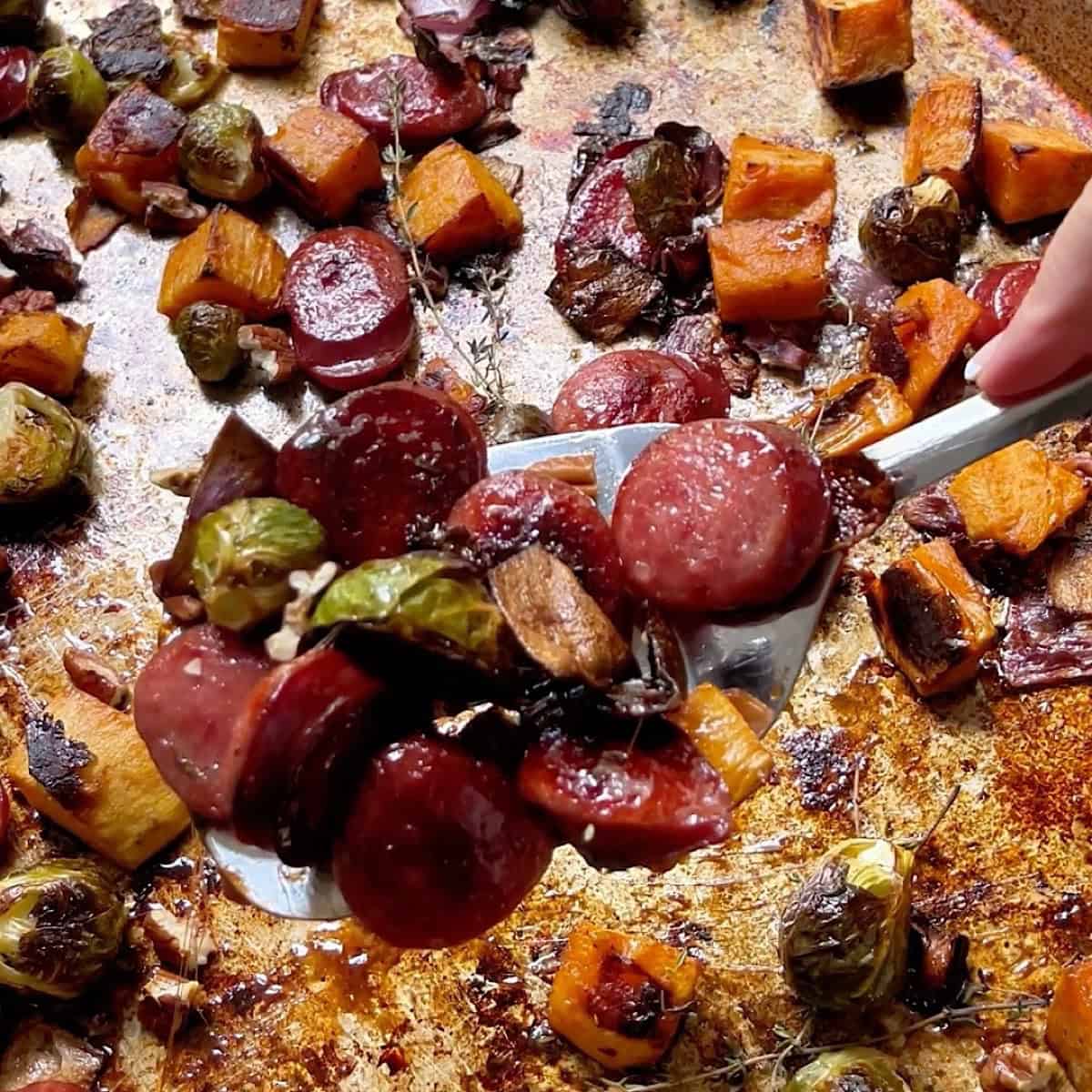 Roasted fall sheet pan dinner with thyme sprigs and pecans.