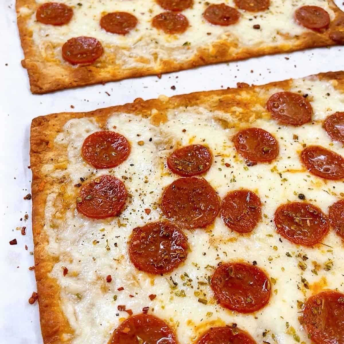 Lavash pizza baked in whole flatbreads before slicing.