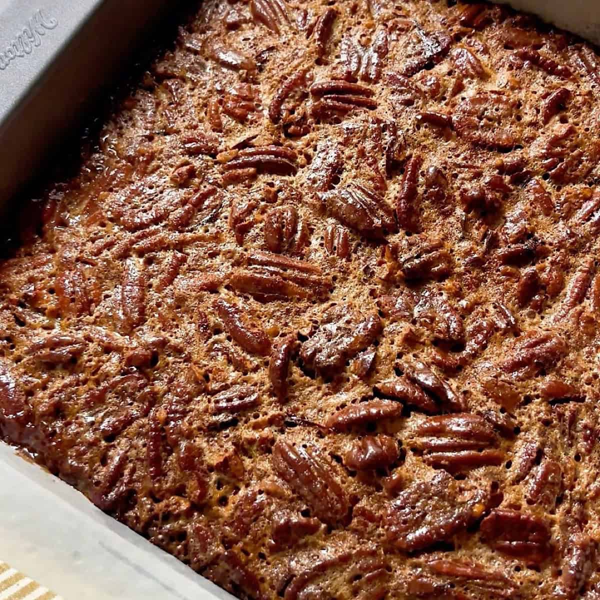 Pecan pie bars baked in the pan and set aside to cool before slicing.
