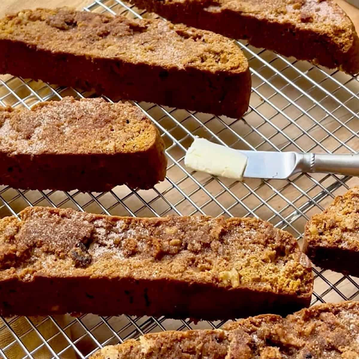 Baked pumpkin spice biscotti on wire rack with cinnamon sugar topping.