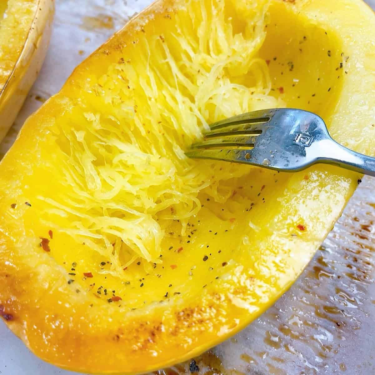Stringing the squash strands with a fork.