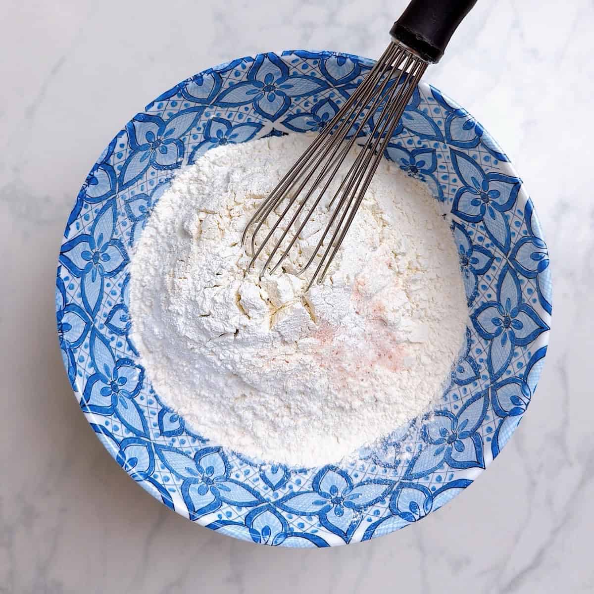 Whisking dry ingredients in a bowl.