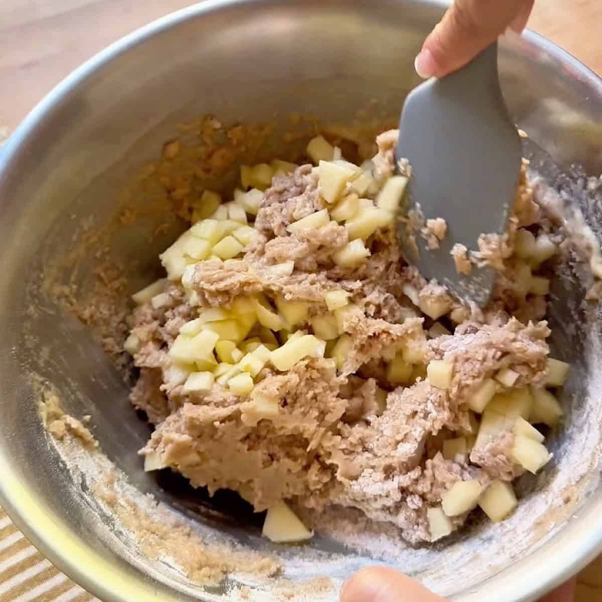 Folding the apples into the jumbo muffin batter.