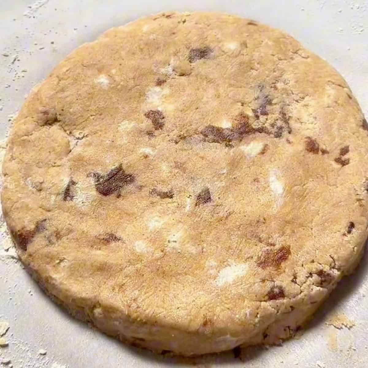 Cinnamon scone dough with cinnamon filling shaped into a six inch circle.