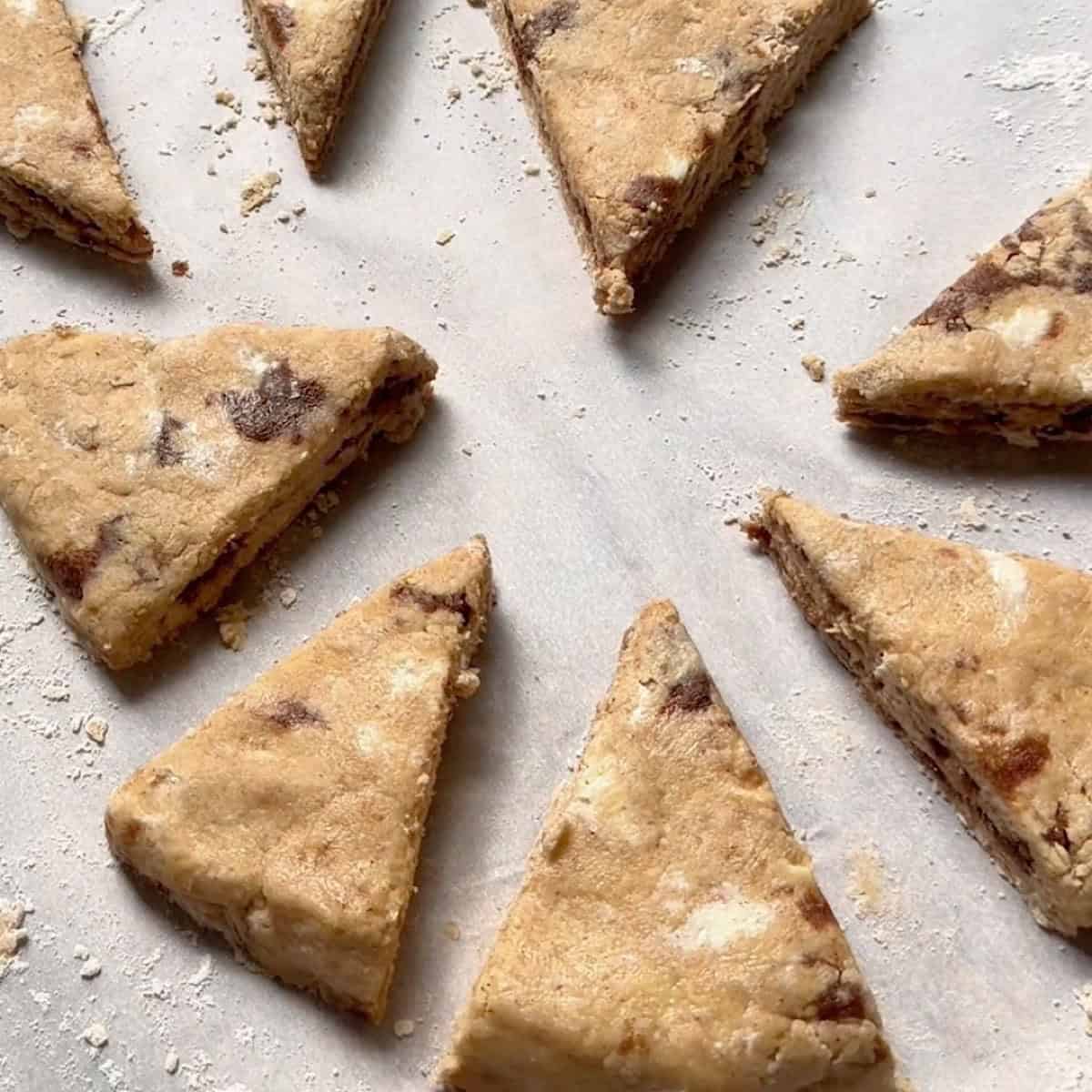 Cinnamon scone dough cut into wedges.