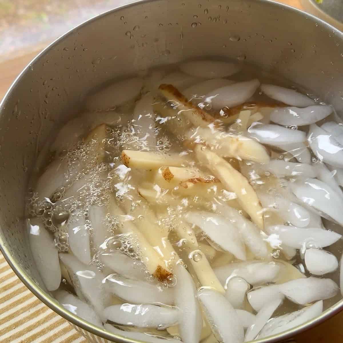 French fries soaking in an ice bath.