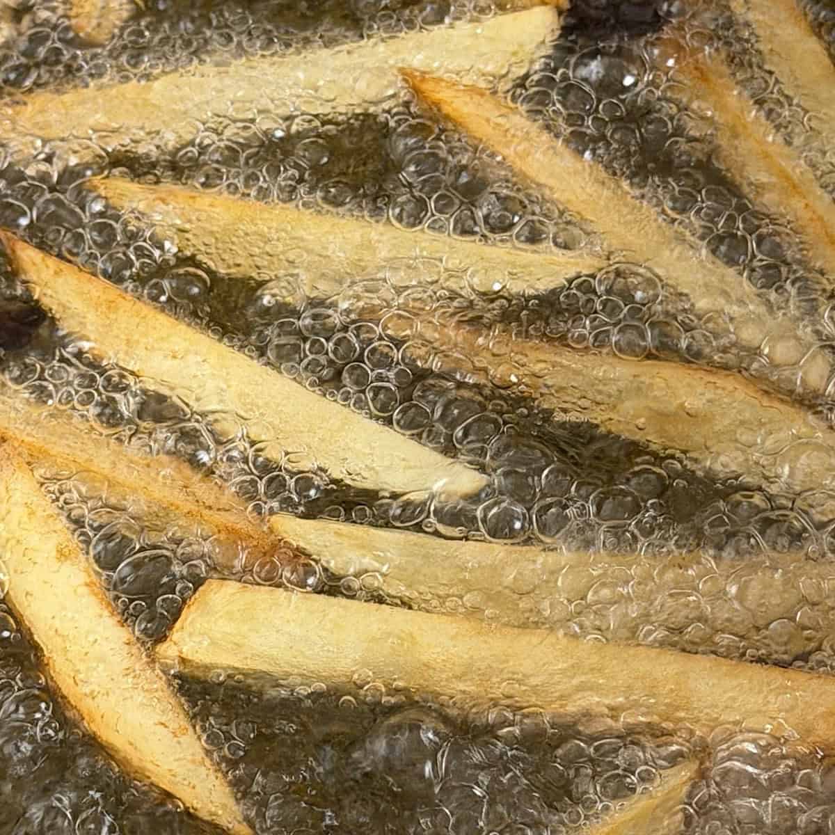 Potatoes deep frying in peanut oil.