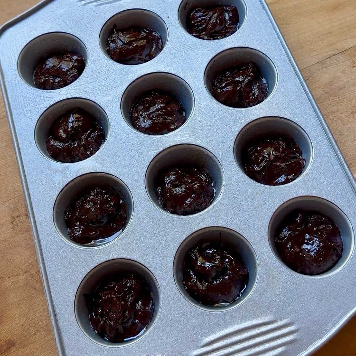 Mini muffin pan with brownie batter filled ⅔ full.