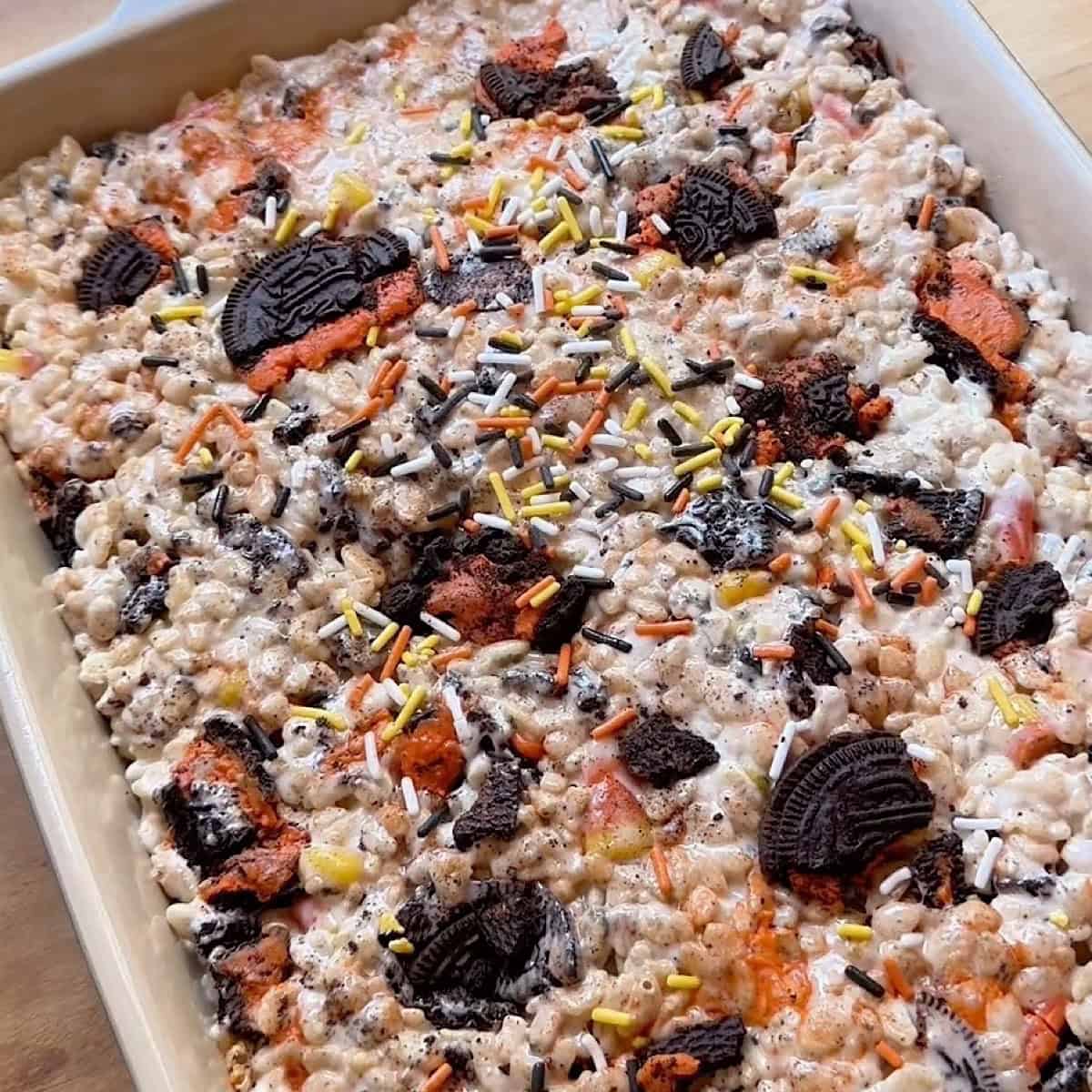 Halloween Rice Krispie treats in a pan with toppings.
