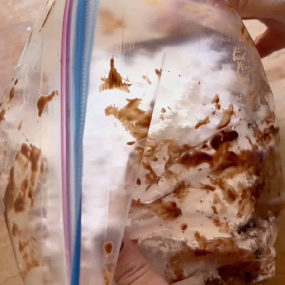 Puppy Chow Mix being coated with powdered sugar in a Ziploc bag.