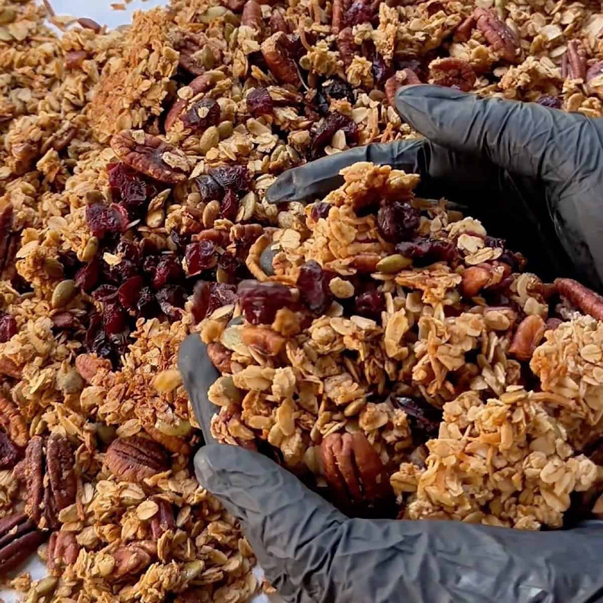 Holding the baked granola in my hands to show clumps.