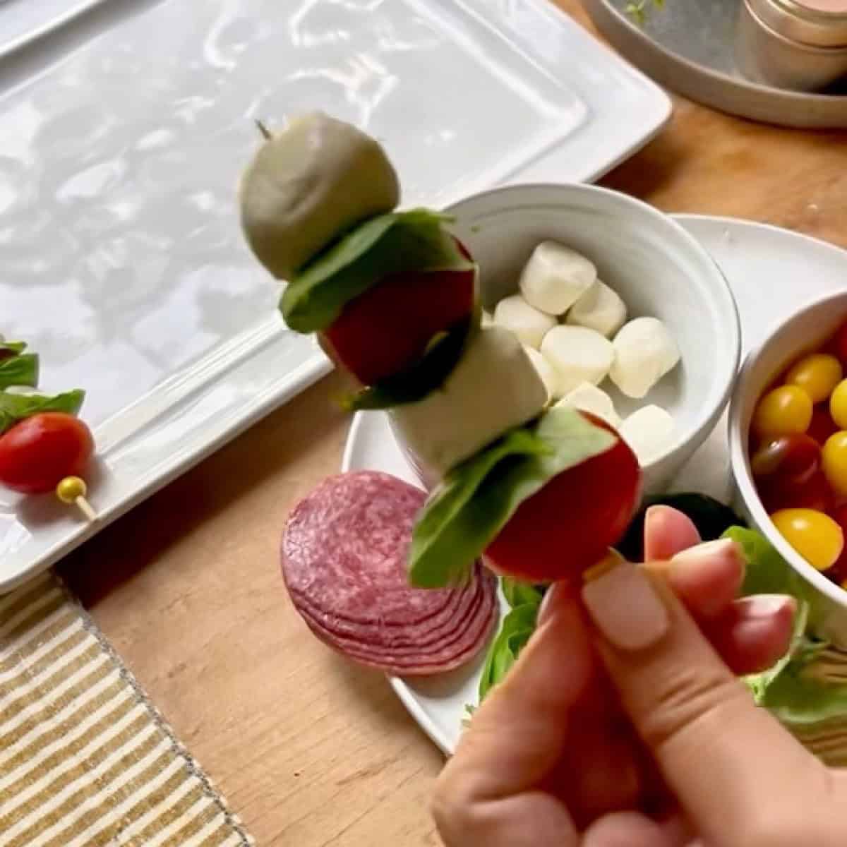 Assembling the caprese skewer.