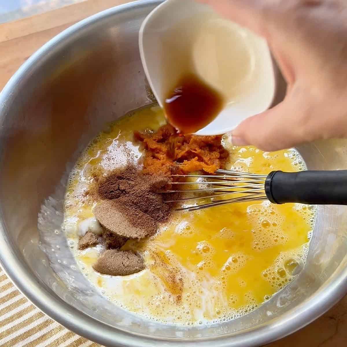 Adding custard ingredients to large mixing bowl for whisking.