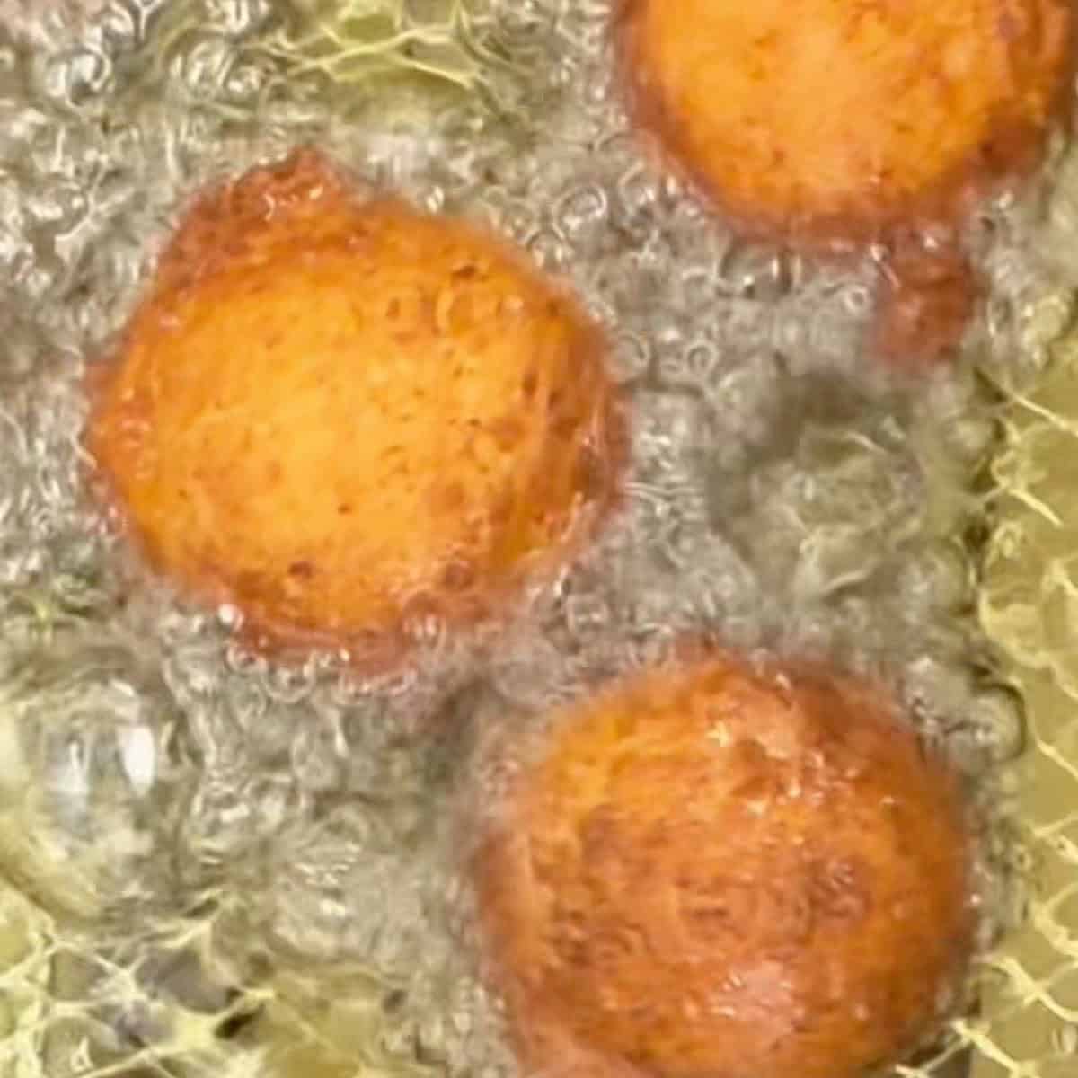Zeppole deep frying in oil.